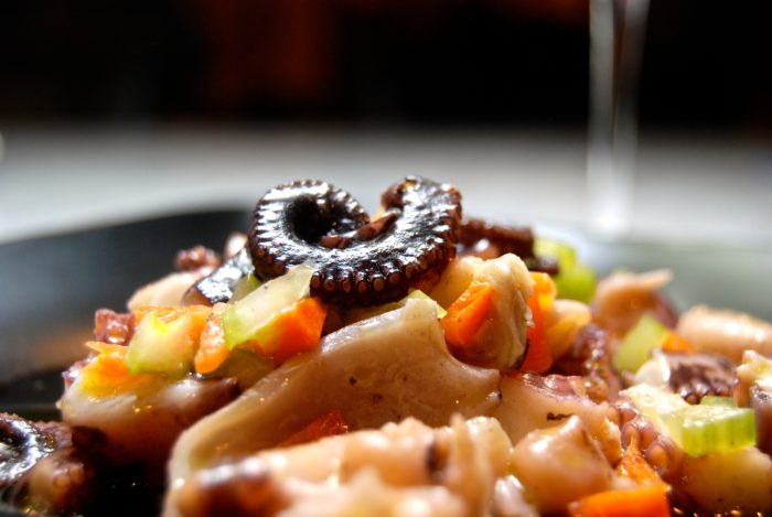 Octopus salad on a black plate