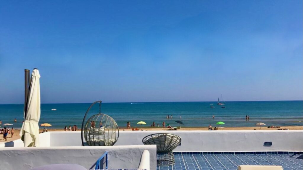 The patio of B&B Mammaliturchi looking out over the emerald Mediterranean sea and a blue sky.