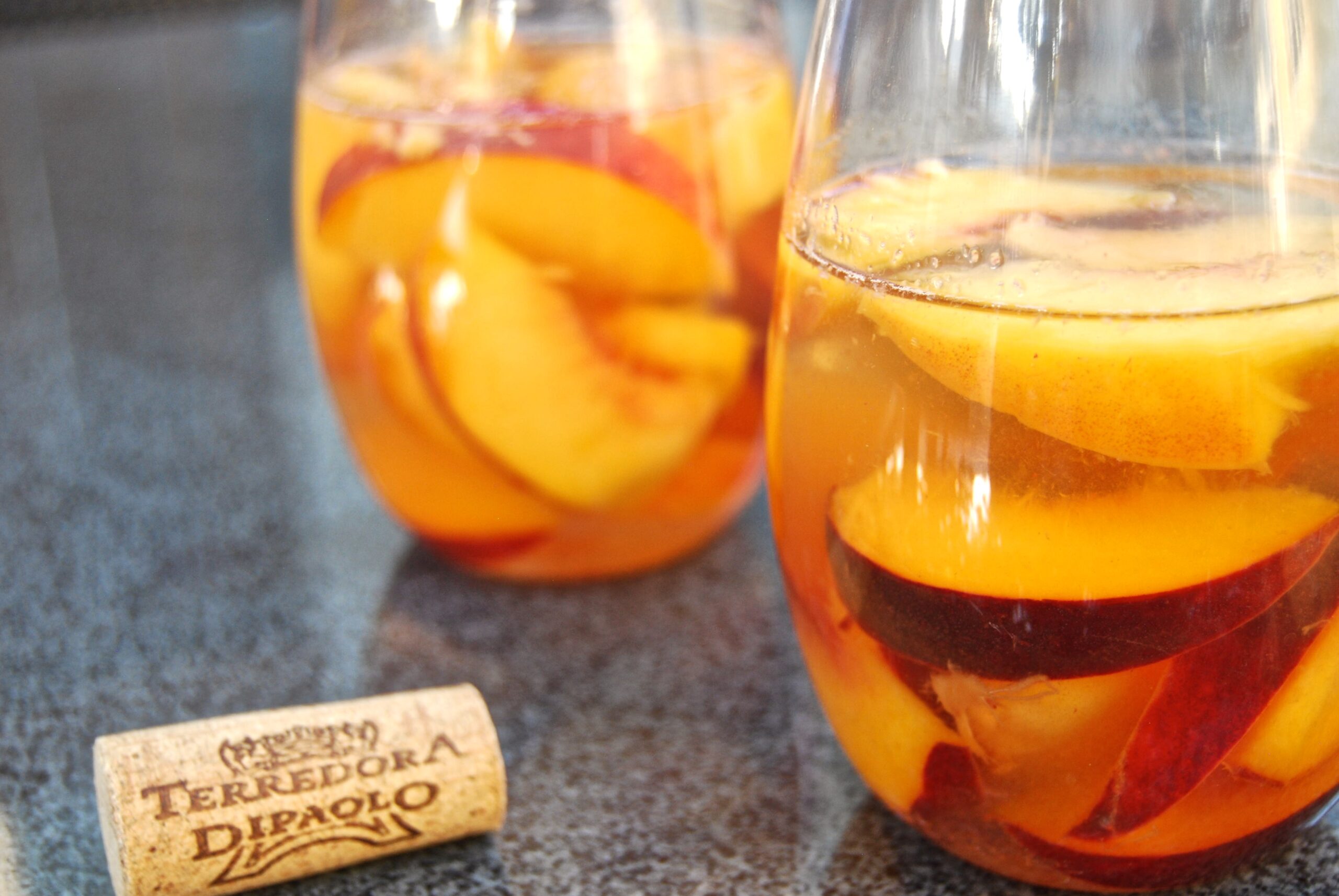 Two glasses of peaches in white wine with a Terredora Di Paolo cork.